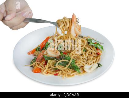 Découpe à la main avec fourchette et spaghetti à la crevette épicée et calmar sur blanc isolé. Banque D'Images