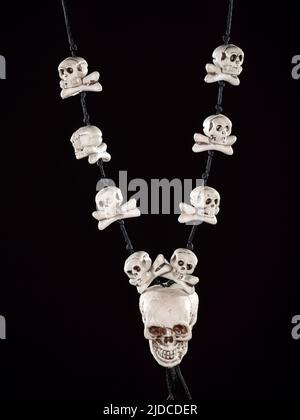 Collier de crâne humain décoratif et d'os isolés sur noir Banque D'Images