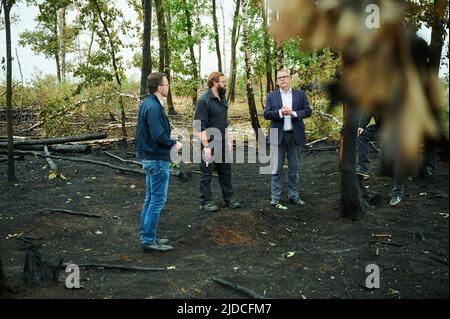 20 juin 2022, Brandebourg, Treuenbrietzen: Michael Stübgen (r, CDU), ministre de l'intérieur de l'État de Brandebourg, se dresse avec Jan Redmann (l, CDU), président du groupe parlementaire de Brandebourg, et Kevin Grigorian (M), directeur des opérations du service des incendies, dans la forêt brûlée de Treuenbrietzen. En attendant, les incendies ont été complètement éteints. De fortes pluies ont aidé les pompiers à éteindre les incendies près de Beelitz et près de Treuenbrietzen, au sud-ouest de Berlin. Au cours du week-end, deux grandes zones forestières avaient brûlé à environ 20 kilomètres d'intervalle dans le district de Potsdam-Mittelmark. P Banque D'Images