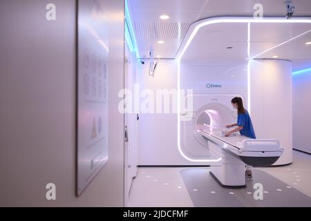 Dresde, Allemagne. 20th juin 2022. Un assistant de radiologie technique médicale prépare l'ACCÉLÉRATEUR LINÉAIRE RM de l'appareil de cancérothérapie à grande échelle pour le traitement dans la salle de traitement du Centre national de recherche radiologique en oncologie - OncoRay. Le nouveau dispositif à grande échelle permet une thérapie innovante contre le cancer à l'hôpital universitaire de Dresde. Il permet une combinaison d'irradiation de photons et d'imagerie en temps réel, ce qui permet la radiothérapie avec une vue simultanée à l'intérieur du corps. Crédit : Robert Michael/dpa/Alay Live News Banque D'Images