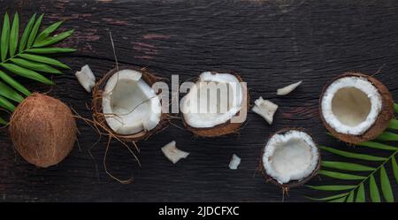 Noix de coco hachée sur fond de bois, vue de dessus. Le lait de coco et les flocons de noix de coco sont des aliments tropicaux Banque D'Images