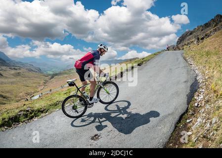 En fin d'après-midi et un cycliste qui monte sur le col HardKnott dans le sport cycliste Fred Whitton Challenge qui s'est tenu dans le district de English Lake, au Royaume-Uni. Banque D'Images