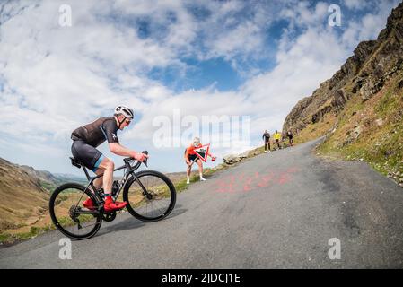 Simon Warren a encouragé un cycliste à monter sur le col HardKnott dans le sport cycliste Fred Whitton Challenge qui s'est tenu dans le district des lacs anglais, au Royaume-Uni. Banque D'Images