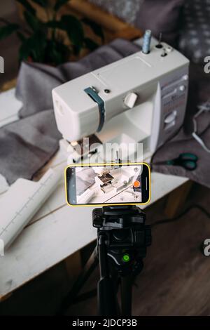 Tournage vidéo du processus de couture, atelier sur la conception de vêtements sur smartphone Banque D'Images