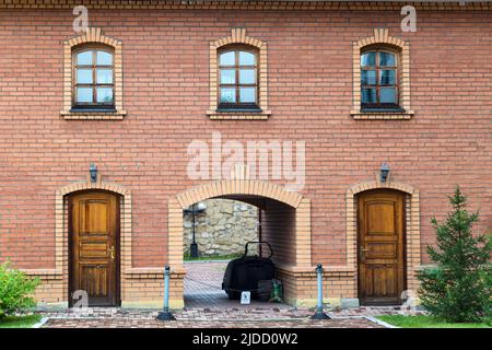 Bâtiment en briques avec une arche, deux entrées et trois fenêtres. Banque D'Images