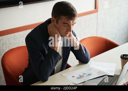Un ouvrier de collier blanc a pris la peine de frotter son cou sur le lieu de travail Banque D'Images