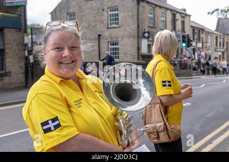 Une participante de musicienne souriante dans la rue au concours du vendredi de Whit Whit de Uppermill Brass Band à Saddleworth, en Angleterre. Banque D'Images
