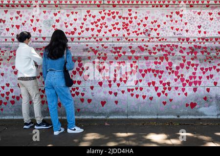 Londres, Royaume-Uni. 20 juin 2022. Les femmes ont vue sur le mur national du Covid en face des chambres du Parlement. Les données actuelles de l'application de l'étude ZOE Covid montrent que les infections symptomatiques quotidiennes sont passées de 114 030 le 1 juin à 188 369 le 17 juin. Une nouvelle étude du professeur Altmann de l'Imperial College de Londres montre qu'une infection précédente fournit peu de protection contre les infections futures, expliquant la hausse plus importante que prévue des cas observés au cours des trois dernières semaines, provoquée par les sous-variantes BA.4 et BA.5 Omicron. Credit: Stephen Chung / Alamy Live News Banque D'Images