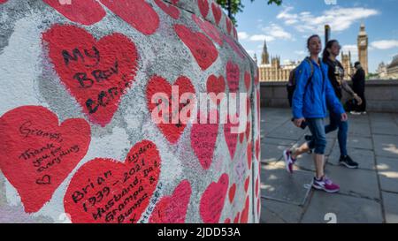 Londres, Royaume-Uni. 20 juin 2022. Les gens passent devant le mur national du Covid en face des chambres du Parlement. Les données actuelles de l'application de l'étude ZOE Covid montrent que les infections symptomatiques quotidiennes sont passées de 114 030 le 1 juin à 188 369 le 17 juin. Une nouvelle étude du professeur Altmann de l'Imperial College de Londres montre qu'une infection précédente fournit peu de protection contre les infections futures, expliquant la hausse plus importante que prévue des cas observés au cours des trois dernières semaines, provoquée par les sous-variantes BA.4 et BA.5 Omicron. Credit: Stephen Chung / Alamy Live News Banque D'Images