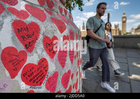 Londres, Royaume-Uni. 20 juin 2022. Les gens passent devant le mur national du Covid en face des chambres du Parlement. Les données actuelles de l'application de l'étude ZOE Covid montrent que les infections symptomatiques quotidiennes sont passées de 114 030 le 1 juin à 188 369 le 17 juin. Une nouvelle étude du professeur Altmann de l'Imperial College de Londres montre qu'une infection précédente fournit peu de protection contre les infections futures, expliquant la hausse plus importante que prévue des cas observés au cours des trois dernières semaines, provoquée par les sous-variantes BA.4 et BA.5 Omicron. Credit: Stephen Chung / Alamy Live News Banque D'Images