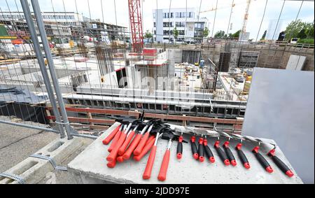 20 juin 2022, Bade-Wurtemberg, Tübingen: Outils à la pose cérémonielle de la pierre de fondation du campus d'innovation de la « Cyber Valley » à Tübingen, en face de la première partie de la coquille. Cyber Valley est la plus grande coopération de recherche en Europe dans le domaine de l'intelligence artificielle avec des partenaires de la politique, de la science, des affaires et de la société. En plus du nouveau bâtiment Cyber Valley I, qui a été approuvé en 2016, le concept global du site de Tübingen comprend deux autres nouveaux bâtiments. Photo: Bernd Weißbrod/dpa Banque D'Images