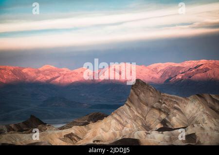 Le soleil se lève au parc national de la Vallée de la mort en Californie, en attrapant les sommets de la chaîne de Panamint depuis Zabriskie point. Banque D'Images