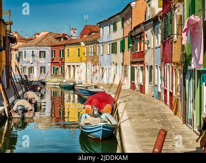 Un canal calme avec des bateaux bordant les deux côtés est typique de la ville endormie de Burano près de Venise. Banque D'Images