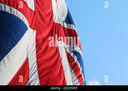 Un drapeau syndical britannique, alias Union Jack, en mouvement par une journée venteuse avec un espace de texte bleu ciel. Banque D'Images