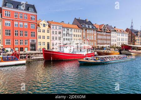 Un bateau touristique passant par Nyhavn, le canal coloré de 17th-siècle en bord de mer à Copenhague, Danemark. Banque D'Images