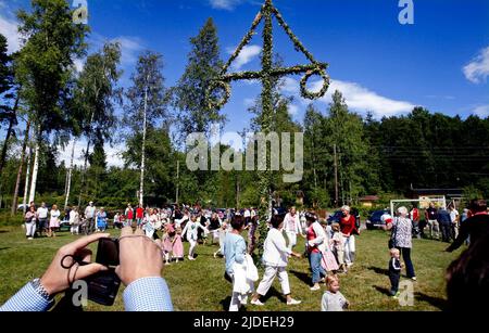 Élever et danser autour d'un maypole lors d'une célébration en milieu d'été en Suède. Banque D'Images