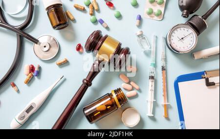 Santé et droit Flat Lay. Jugez le gavel, la médecine et le manteau du médecin sur fond bleu, vue de dessus. Faute professionnelle médicale, préjudice personnel avocat. Banque D'Images