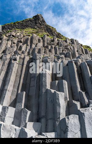 Colonnes de basalte à la base de la falaise de Reynisfjall dans la plage de Reynisfjara dans le sud de l'Islande Banque D'Images