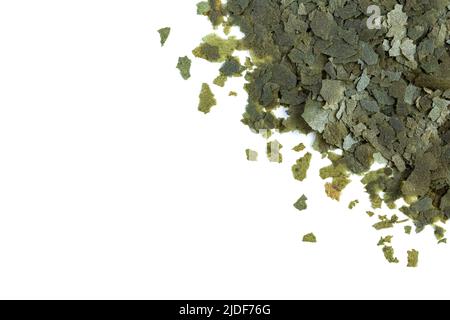 Vert nourriture sèche sous forme de flocons pour poissons d'aquarium sur fond blanc. Vue de dessus Banque D'Images