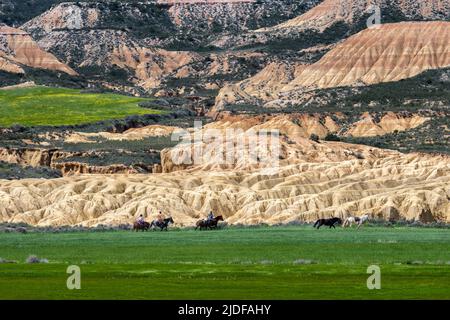 Au printemps, un groupe de touristes suit leur guide lors d'une balade à cheval dans le désert de Bardenas, en Espagne. Bardenas Realese, Espagne, 30 avril 2022. Banque D'Images