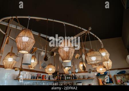 Des lampes en osier sont suspendues au plafond dans un café. Comptoir dans un restaurant avec éléments décoratifs Banque D'Images