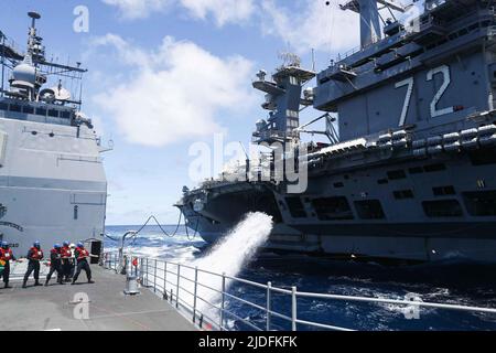 LES marins DE LA MER DES PHILIPPINES (18 juin 2022) gèrent la ligne téléphonique et de distance lors d'un réapprovisionnement en mer avec le porte-avions de la classe Nimitz USS Abraham Lincoln (CVN 72) à bord du croiseur à missiles guidés de la classe Ticonderoga USS Mobile Bay (CG 53). Abraham Lincoln Strike Group est en cours de déploiement prévu dans la zone d'exploitation de la flotte américaine 7th afin d'améliorer l'interopérabilité par le biais d'alliances et de partenariats tout en servant de force d'intervention prête à l'emploi pour soutenir une région Indo-Pacifique libre et ouverte. (É.-U. Photo marine par Spécialiste communication de masse 3rd classe Alonzo Martin-Frazier) Banque D'Images