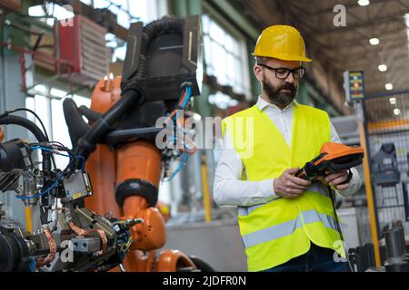 Ingénieur en automatisation qui tient le scanner en usine. Banque D'Images