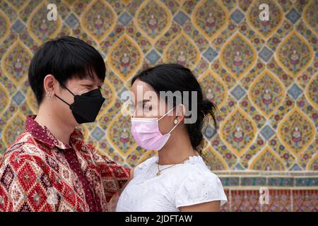 Couple transgenre portant un masque facial regardant l'un l'autre dans un temple bouddhiste Banque D'Images