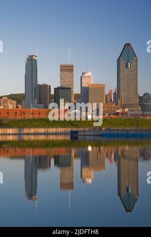 Skyline de Montréal reflété dans le bassin Peel au lever du soleil, Québec, Canada. Banque D'Images