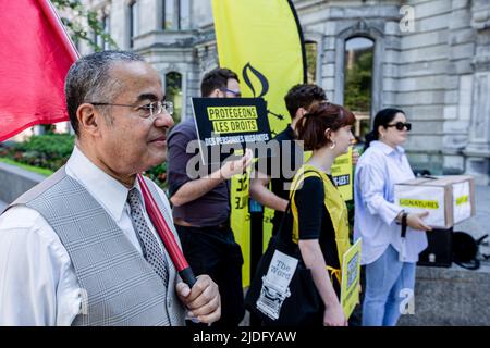 Montréal, Canada. 20th juin 2022. Le personnel d'Amnesty International tient des pancartes en faveur des droits de l'homme pendant la manifestation. En cette Journée mondiale des réfugiés, Amnesty International Canada, en collaboration avec Human Rights Watch, a organisé une manifestation devant le bureau du Premier ministre à Montréal pour demander la fin de la détention énergique des réfugiés et des demandeurs d'asile au Québec. Nommée #BienvenueAuCanada, la campagne a cherché des signatures de politiciens québécois pour mettre fin à des contrats avec des prisons provinciales pour prendre des migrants. Crédit : SOPA Images Limited/Alamy Live News Banque D'Images