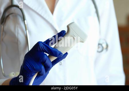 Praticien en blouse médicale tenant la sonde à ultrasons à la main Banque D'Images
