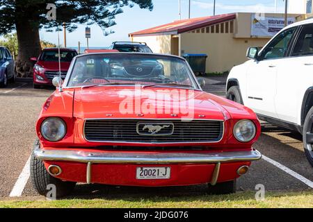 Modèle 1966 Rouge Ford Mustang cabriolet Classic voiture avec toit en bas garée à Newport Beach à Sydney, logo mustang sur la calandre, Sydney, Australie Banque D'Images