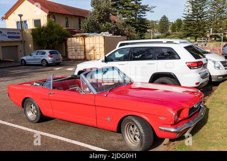 Voiture classique, véhicule cabriolet Ford Mustang 1966 rouge garée à Newport Beach à Sydney avec le toit abaissé, Nouvelle-Galles du Sud, Australie Banque D'Images