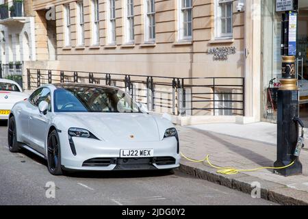 Voiture électrique Porsche chargée à partir d'un poste de lampe à Londres, Angleterre, Royaume-Uni, samedi, 21 mai, 2022. Banque D'Images