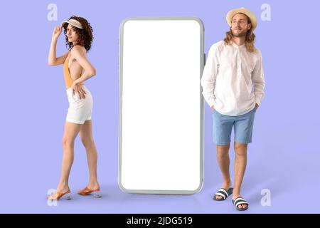 Jeune couple élégant en vêtements d'été et avec téléphone portable avec écran blanc sur fond de couleur Banque D'Images