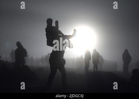 Stonehenge Wiltshire Royaume-Uni 21st juin 2022. Les fêtards attendent le lever du soleil. Pour la première fois depuis 2019, les fêtards, dont Hippies et Druides, reviennent à Stonehenge pour célébrer le solstice d'été. Des milliers de personnes sont descendues sur les vieilles pierres pour assister au lever du soleil dans des conditions brumeuses le plus long jour de l'année. Le soleil se leva à 4:49am et le solstice officiel commença à 10:13am CEST. L'accès contrôlé aux pierres par le patrimoine anglais a été interrompu depuis trois ans en raison de la pandémie du coronavirus, bien que les Druides aient toujours réussi à accéder à Stonehenge pendant les périodes de fermeture SolsticeÕs. Crédit : mars Banque D'Images