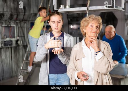 Petits-enfants et grands-parents dans la salle d'évacuation Banque D'Images