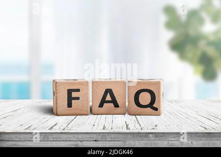 FAQ réponses et questions signe fait de blocs de bois. Debout sur une table dans un salon lumineux. Banque D'Images