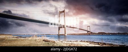 Pont sur l'eau dans un paysage spectaculaire avec des nuages sombres Banque D'Images