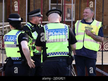 Leicester, Leicestershire, Royaume-Uni. 21st juin 2022. Les agents de police parlent à un travailleur ferroviaire debout sur une ligne de piquetage pendant la première des trois grèves nationales. Le TMT a appelé à des grèves sur les réductions d'emplois, les salaires et les conditions. Credit Darren Staples/Alay Live News. Banque D'Images