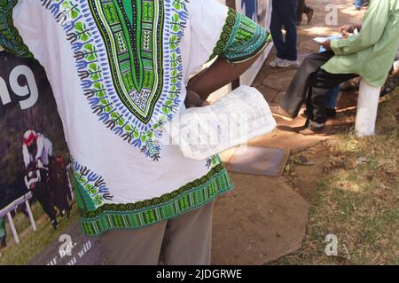 Spectateurs étudiant la cote de course, Hippodrome de Ngong, chemin Ngong, Nairobi, Kenya. 1 mars 2015 Banque D'Images