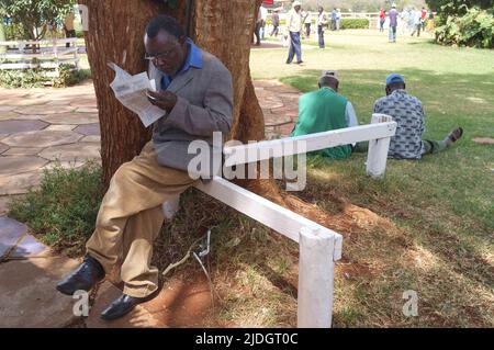 Spectateurs étudiant la cote de course, Hippodrome de Ngong, chemin Ngong, Nairobi, Kenya. 1 mars 2015 Banque D'Images