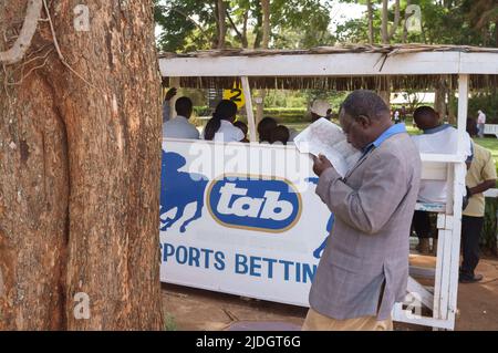 Spectateurs étudiant la cote de course, Hippodrome de Ngong, chemin Ngong, Nairobi, Kenya. 1 mars 2015 Banque D'Images