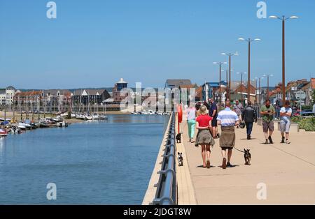 Littlehampton, West Sussex, Royaume-Uni. Les gens marchent le long du sentier de la rivière sur la rive est de l'Arun. Montre le centre-ville et les yachts au-delà. Banque D'Images