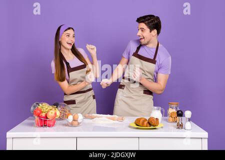 Photo de la belle dame belle gars ont l'amusement préparer la pâte dansant isolé sur fond violet couleur Banque D'Images