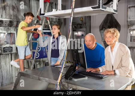 Les grands-parents et les petits-enfants ont résolu les énigmes dans la salle d'évacuation Banque D'Images