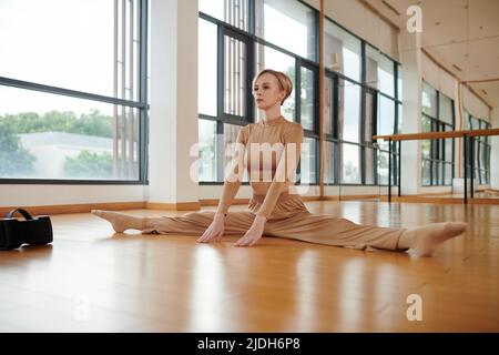 Faites de la danseuse une danseuse en faisant des fentes latérales pour étirer les jambes avant l'entraînement Banque D'Images