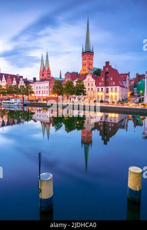 Lubeck, Allemagne. Image de paysage urbain du bord de la rivière Lubeck avec reflet de la ville de la rivière Trave au coucher du soleil. Banque D'Images