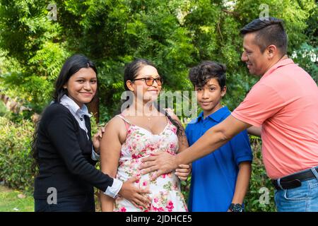 Latino Family tient les mains de sa mère sur son ventre Banque D'Images