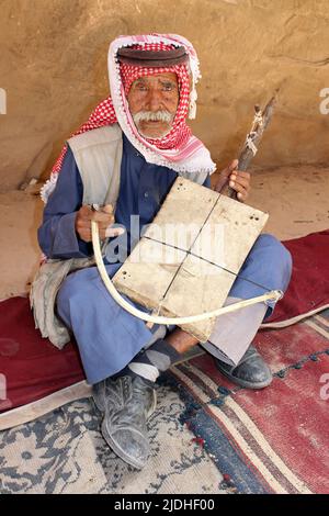 Vieil homme jouant un instrument de musique bédouin traditionnel (Rababah) Banque D'Images